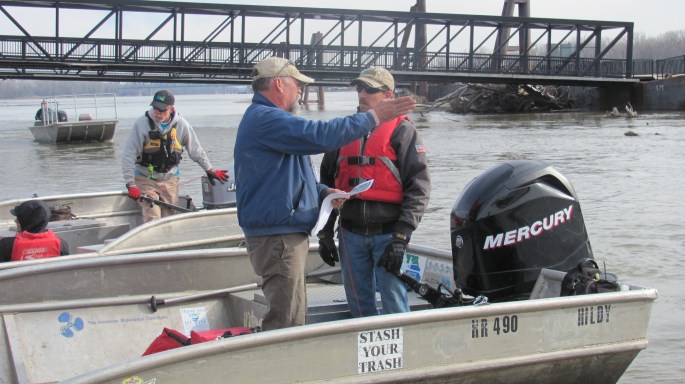 Dispatcher Jeff Barrow discussing trash locations upriver.  Scouts find the trash hot spots the day prior and mark with blue bags.